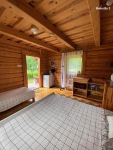 a large room with a bed and a stove at Akmens sala in Vecpiebalga