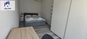 Zimmer mit einem Bett und einem Holztisch in der Unterkunft CITY VIEW Tołstoja - KLIMATYZACJA in Świdnica