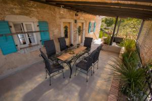 a patio with a wooden table and chairs at Villa Ca'Pietra, rustic stone house in Malinska