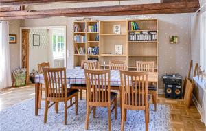 a dining room with a table and chairs and bookshelves at Beautiful Home In Varberg With Wifi And 4 Bedrooms in Varberg