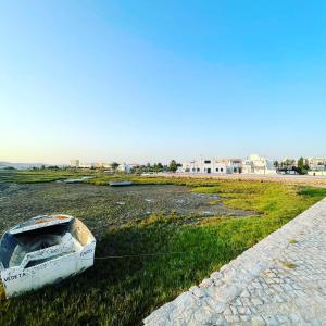 a boat sitting on the grass next to a road at Fisherman´s Cave in Faro