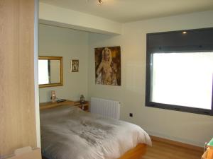 um quarto com uma cama grande e uma janela em Can Clapa em Les Borges del Camp