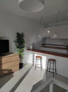 a kitchen with two stools and a counter with a tv at CRÁTER 2 in El Paso