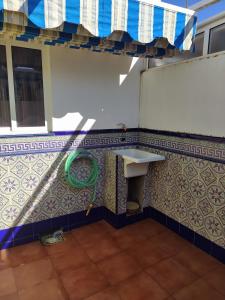 a bathroom with a sink and a tiled wall at Chalet adosado con azotea andaluza y patio, junto a la playa in Isla Cristina