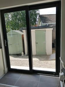 a sliding glass door with a view of a yard at Mews self catering in Kilpedder