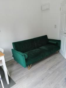 a green couch sitting in a living room at Mews self catering in Kilpedder
