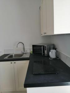 a kitchen with a sink and a microwave at Mews self catering in Kilpedder