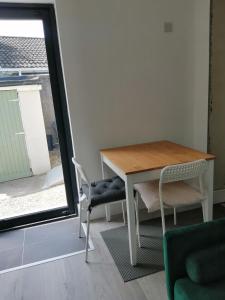uma mesa e cadeiras num quarto com uma janela em Mews self catering em Kilpedder
