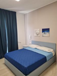 een slaapkamer met een bed met een blauwe sprei bij B&B Rayl in Formia