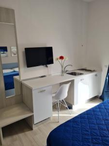 een kamer met een bureau, een tv en een computer bij B&B Rayl in Formia