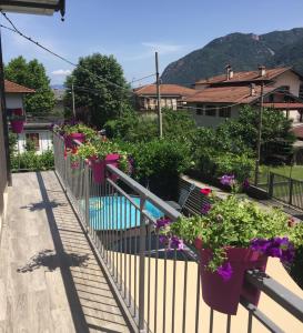 a balcony with flowers and a swimming pool at Da Tosca in Gravellona Toce