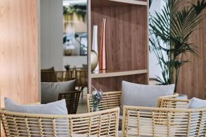 a room with wicker chairs and a mirror at Helios Mallorca Hotel & Apartments in Can Pastilla