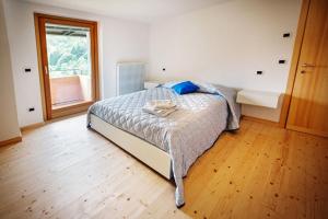 a bedroom with a bed and a window at La Marmote Albergo Diffuso di Paluzza Aip in Paluzza