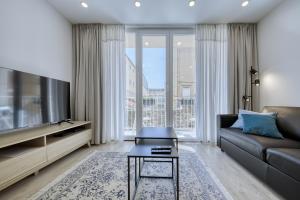 een woonkamer met een bank en een groot raam bij Sidra city apartment in Zadar
