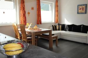 una sala de estar con una mesa con un bol de fruta en Haus Eder, en Maurach
