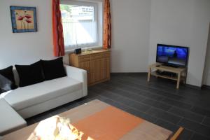 ein Wohnzimmer mit einem Sofa und einem TV in der Unterkunft Haus Eder in Maurach