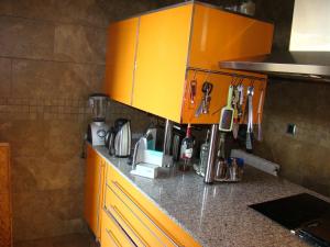 a kitchen with orange cabinets and a counter top at Can Clapa in Les Borges del Camp