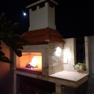 a brick oven with a fire in it at night at Villa Sv. Vid in Sevid