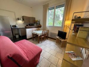 een woonkamer met een bank en een tafel en een keuken bij La Résidence - n° 08 - T2 classé** in Gréoux-les-Bains