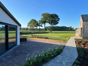 un jardín con una pasarela de piedra junto a una casa en Whaaw Herentals, en Herentals