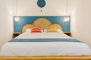 a bedroom with a large bed with three pillows at L'imprévu L'annexe in Cotonou