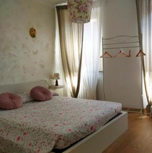 Un dormitorio con una cama con almohadas rosas. en La Casetta en Ancona