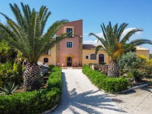 a house with palm trees in front of a driveway at Torre Tabia in Sciacca
