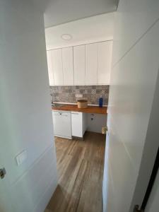 cocina con armarios blancos y suelo de madera en For You Rentals Pradera San Isidro SCA3, en Madrid