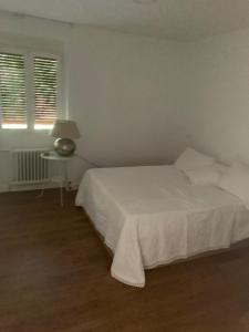 Dormitorio blanco con cama blanca y mesa en For You Rentals Pradera San Isidro SCA3, en Madrid