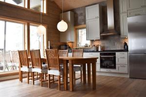 a kitchen with a wooden table and some chairs at Alpstigen 10A - Newly built sports lodge with amazing views in Järvsö