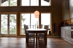 cocina con mesa, sillas y ventanas en Alpstigen 10A - Newly built sports lodge with amazing views, en Järvsö