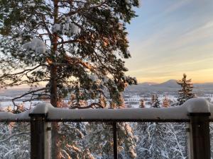 a snow covered fence with a view of a city at Alpstigen 10A - Newly built sports lodge with amazing views in Järvsö