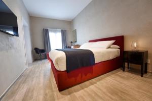 a bedroom with a bed and a desk and a window at Quaint Boutique Hotel Sannat in Sannat