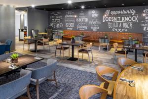 a restaurant with tables and chairs and a chalkboard at Holiday Inn Coventry M6, J2, an IHG Hotel in Coventry
