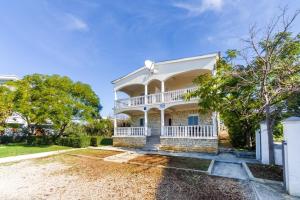 a large white house with a large yard at Apartment Vrsi at the Beach in Vrsi