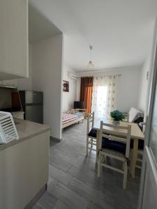 eine Küche und ein Wohnzimmer mit einem Tisch und Stühlen in der Unterkunft Bianca Apartments in Velipojë