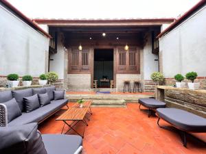 a patio with couches and tables in a building at 金門 日玥居 古厝民宿 Sunmoon19 B&B in Jinning