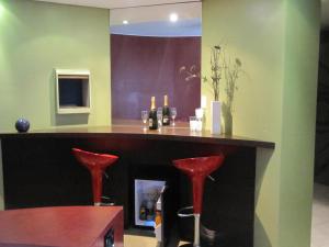 een bar met twee rode krukken in een kamer bij Uman Hotel -Motel- in Buenos Aires