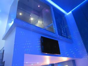 een blauwe kamer met een tv aan de muur bij Uman Hotel -Motel- in Buenos Aires