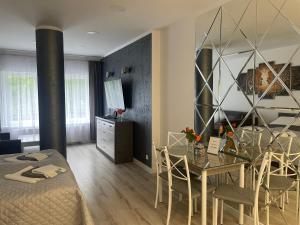 - un salon et une salle à manger avec une table et des chaises dans l'établissement Apartamenty "SZKIEŁKO", à Koszalin