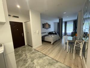 a living room with a bed and a dining room at Apartamenty "SZKIEŁKO" in Koszalin