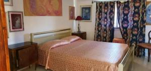 um quarto com uma cama, uma mesa e uma janela em Appartamento Capo Mannu-mandriola em Putzu Idu
