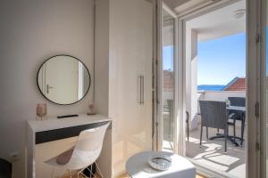 a white room with a mirror and a table and chairs at Apartments Mistral in Bol +77 photos
