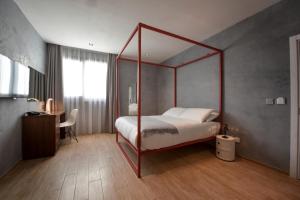 a bedroom with a canopy bed and a desk at Quaint Boutique Hotel Sannat in Sannat