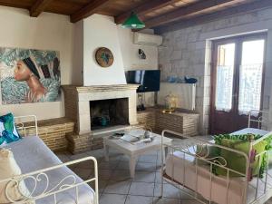 a living room with a couch and a fireplace at Deep Blue Villas in Vasilikos