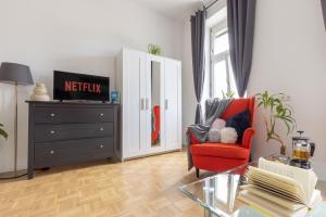 salon z czerwonym krzesłem i komodą w obiekcie Yeshello Vienna Central Station Apartment w Wiedniu