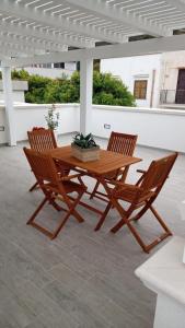 una mesa de madera y 2 sillas en el patio en Il Corallo en Marettimo