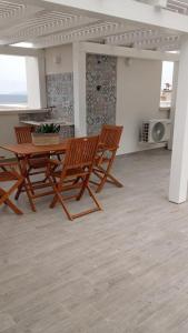 Habitación con 2 sillas de madera y mesa. en Il Corallo, en Marettimo