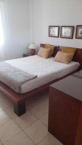a bedroom with a large bed with white sheets and pillows at Apartamento Solar dos Pinheiros in Vilamoura