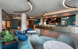 hol ze stołami i krzesłami oraz bar w obiekcie Hunguest Hotel Bál Resort w mieście Balatonalmádi